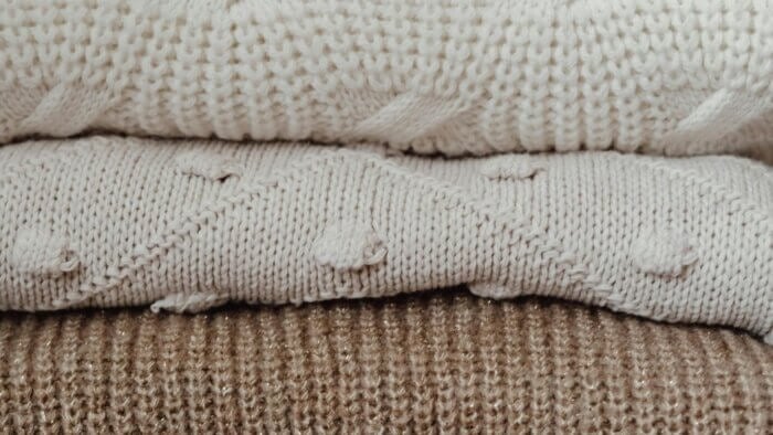 Three jumpers made from plant wool in a pile
