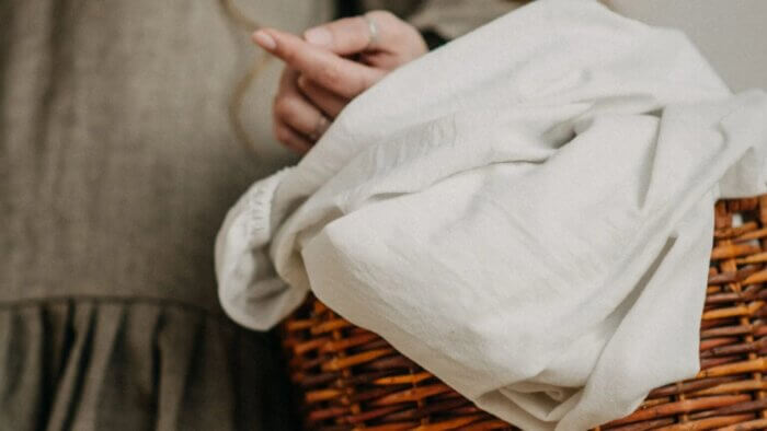 A woman holding a basket containing plant wool