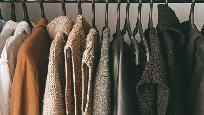 A selection of sweaters made from plant wool hanging from hangers